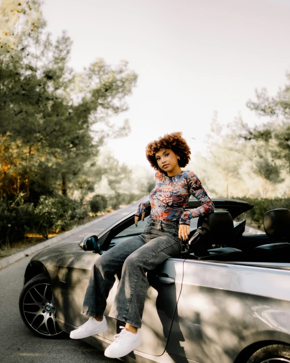 an image of a woman sitting in the back of a convertible car