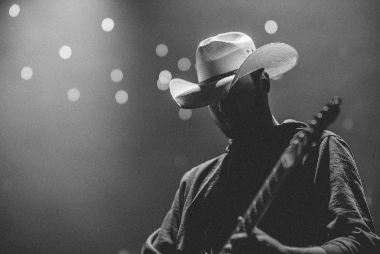 a man with a hat is playing guitar