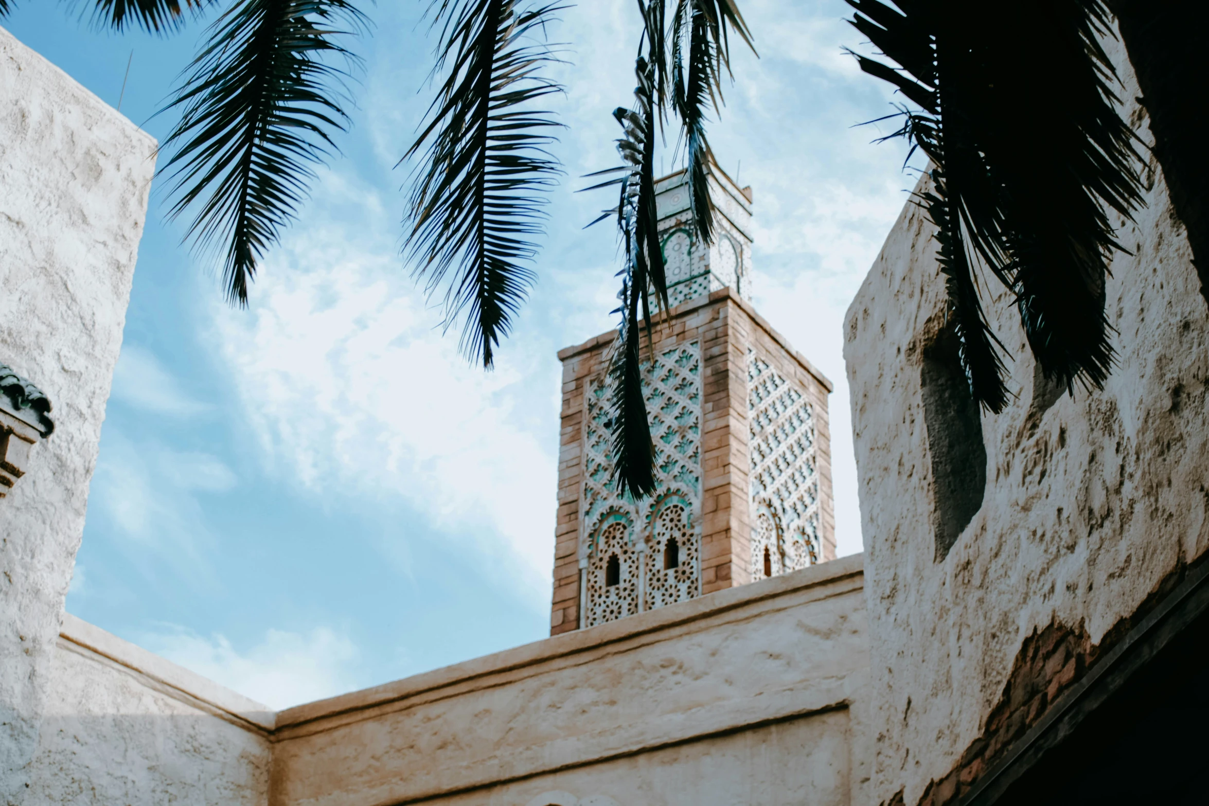 a clock tower surrounded by palm trees and blue sky
