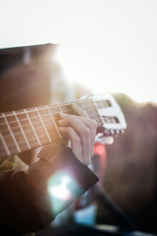 a man that is playing a guitar near the sun