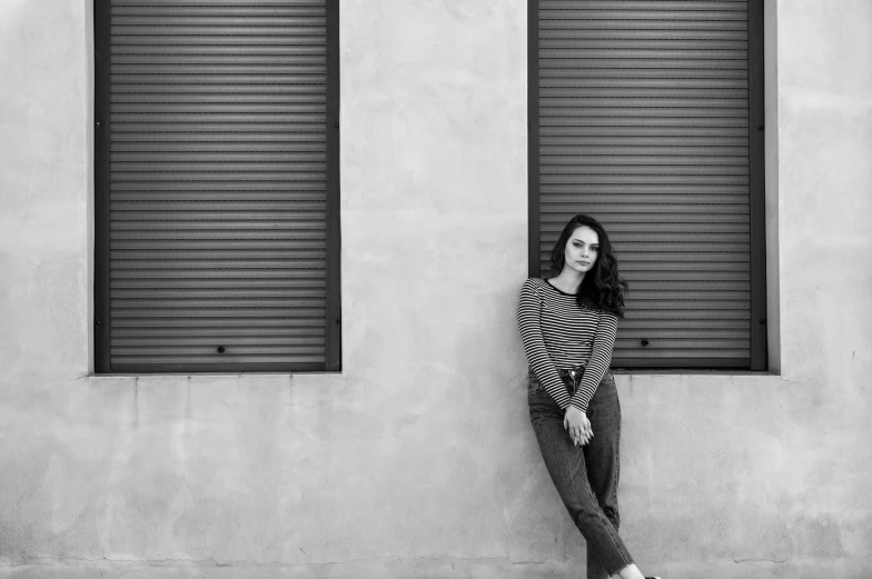 a beautiful woman posing for a portrait in front of some shutters