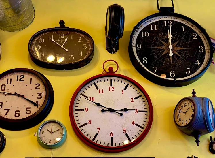 various clocks all displaying different time zones on the wall