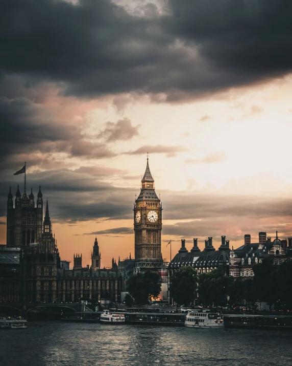 a clock tower with a cloudy sky and dark clouds above it