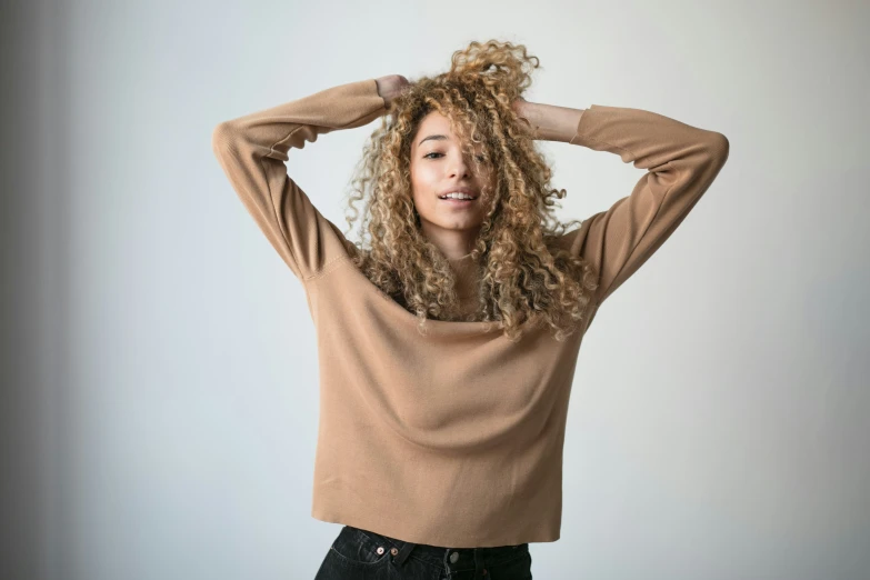 a woman with curly hair posing in a studio