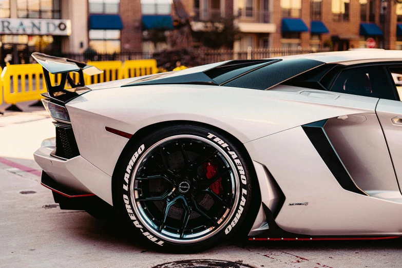 a white sports car with black rims sits on the street