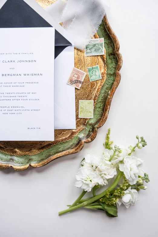 wedding details, envelope, and napkins laid out on an abstract leaf - form plate