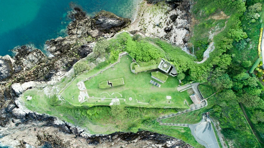 the aerial view of a small house and surrounding grassy area