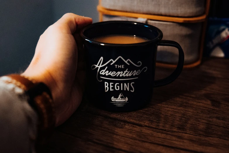 someone holding a coffee mug that is in their hand