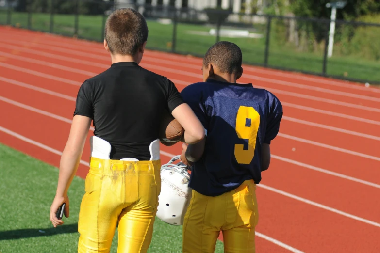 two young football players standing on a field