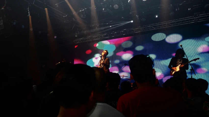 a band playing on stage in the dark