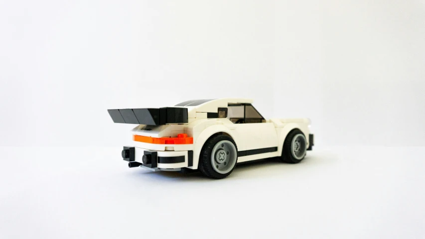 a lego car sitting next to a white wall