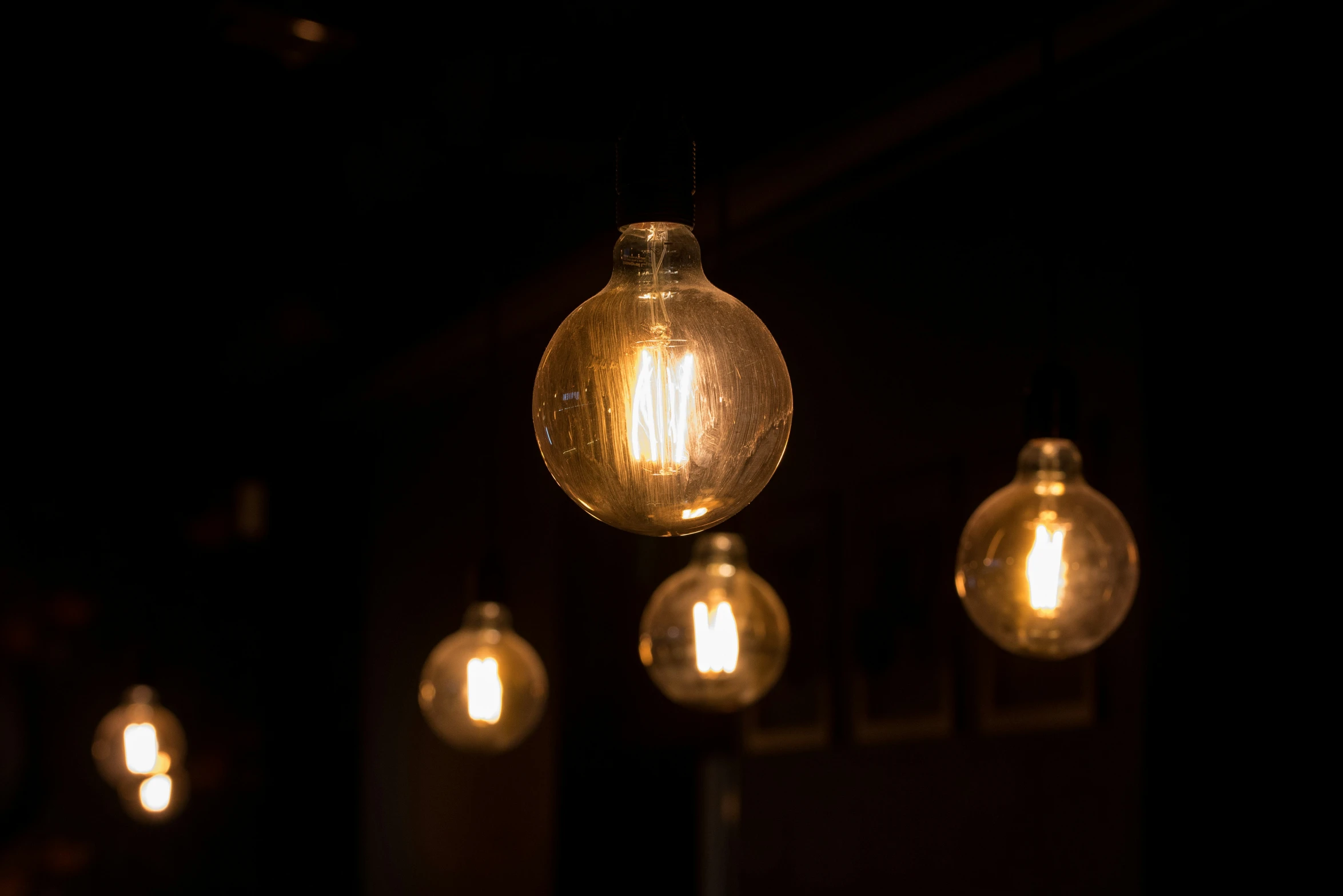 four light bulbs are lit up in the dark