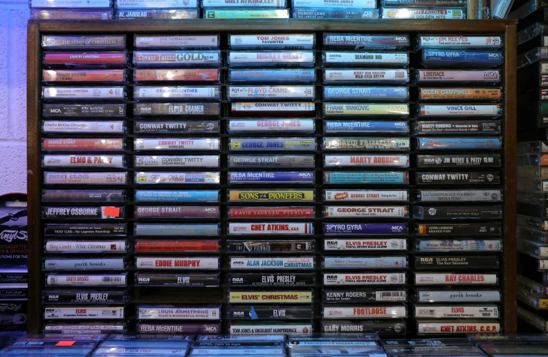 a shelf of different kinds of cd's with a bunch of them stacked on top