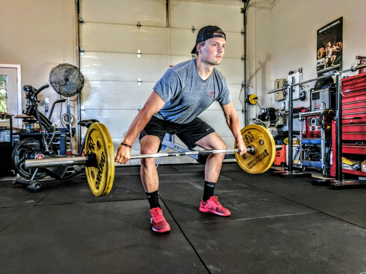 a man squats while holding a barbell in his hands