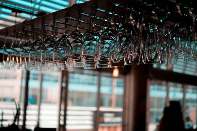 a large amount of glasses hanging from the ceiling