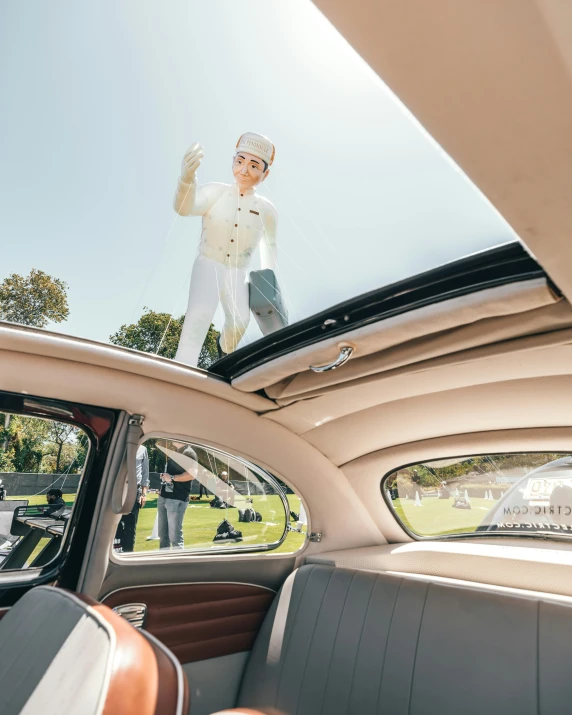 a white chef is riding atop the back of a car