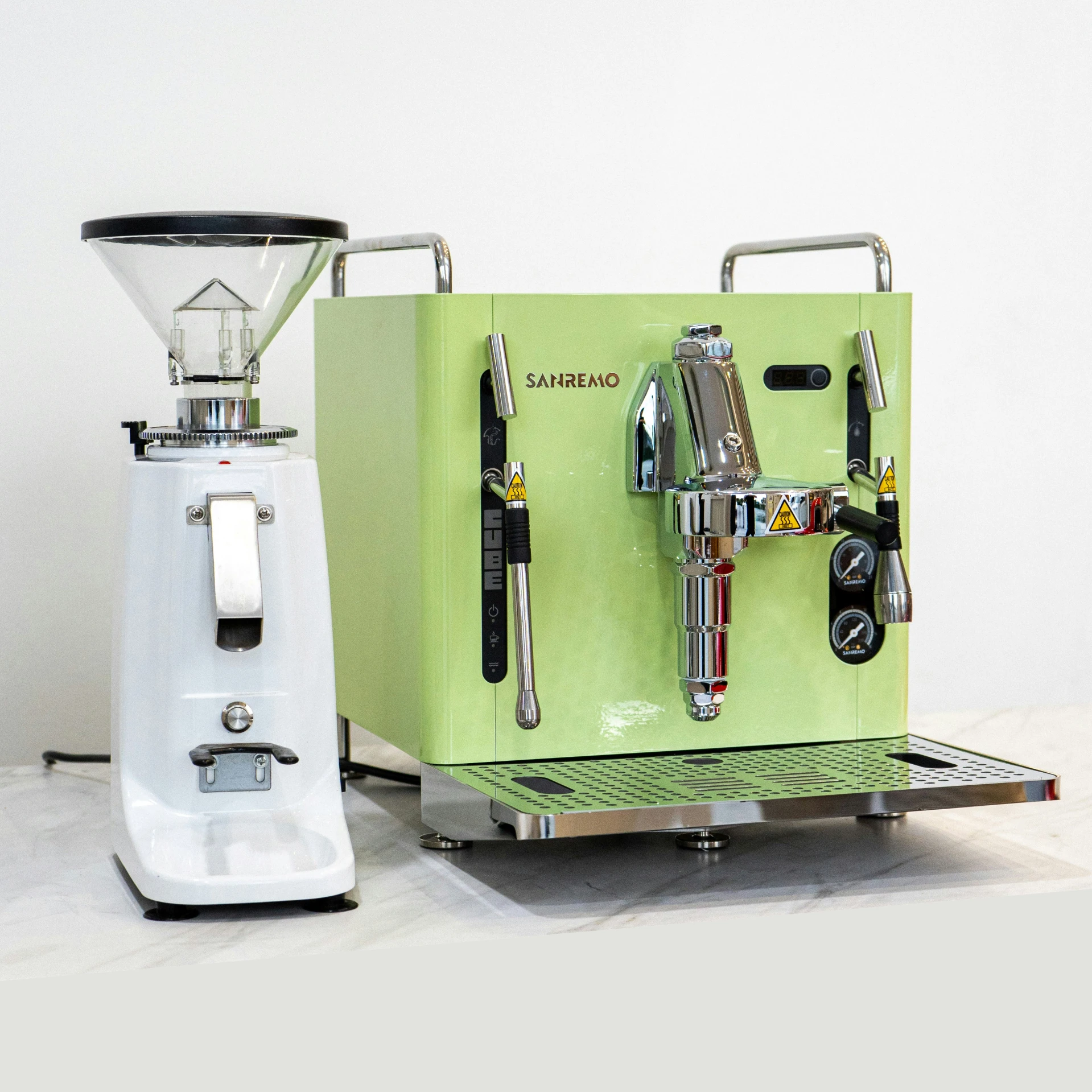 a green and white coffee machine sitting next to an electronic device