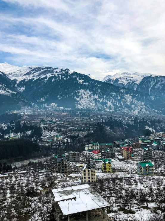 a picture taken from a high point, of a mountain range in the winter with snow - capped mountains