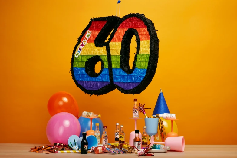 a celetion backdrop with balloons, party hats and streamers