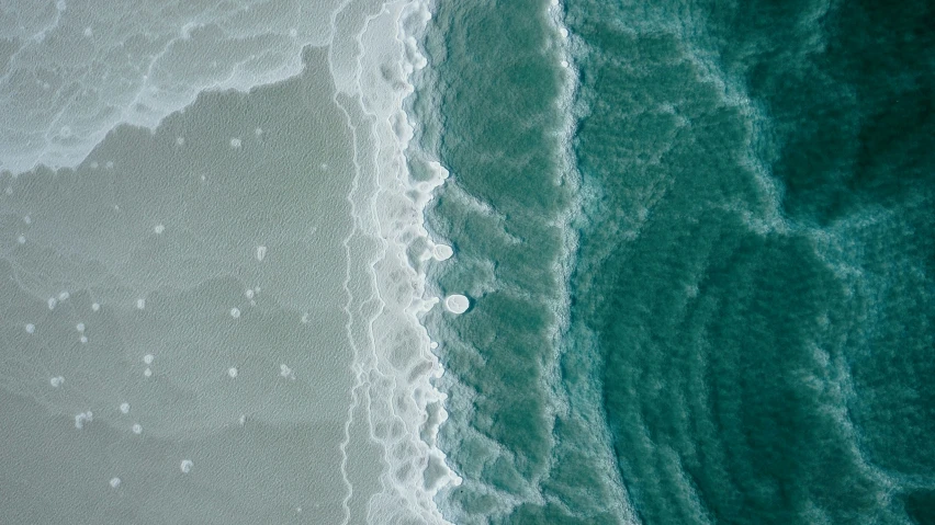 a po taken from a sea airplane of waves coming in from a beach