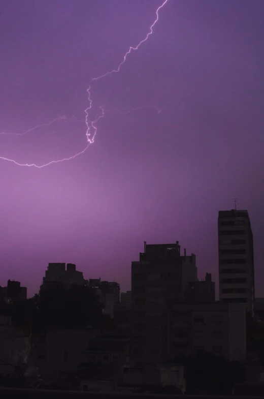 a lightning bolt striking above city at night