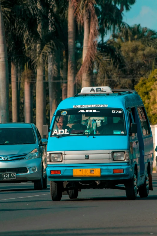 two blue vans are driving down the street