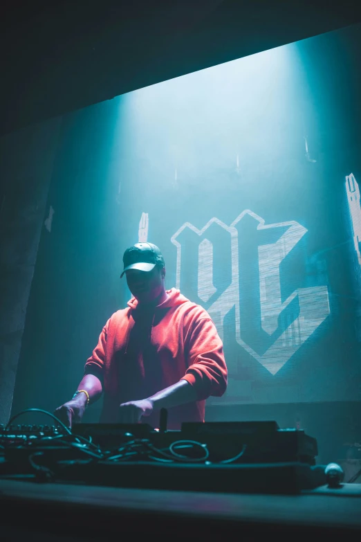 a dj wearing a helmet is mixing music in front of a large video screen