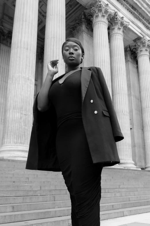 woman in business attire standing on steps near columns