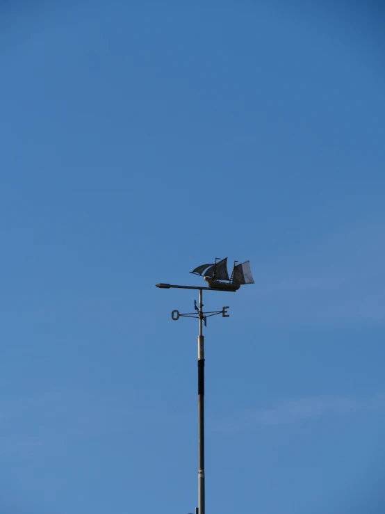 an old fashioned weather vane with a bird sitting on top