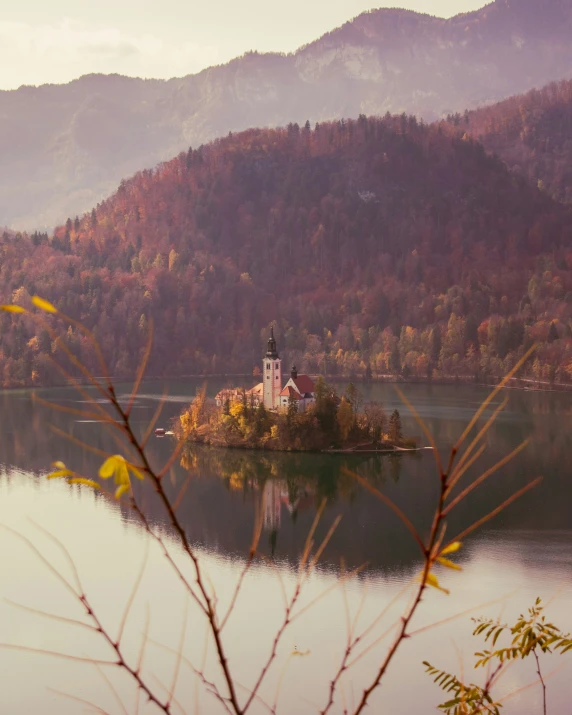 an island in the middle of a lake surrounded by mountains