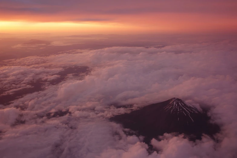 some clouds and some red sky over a mountain