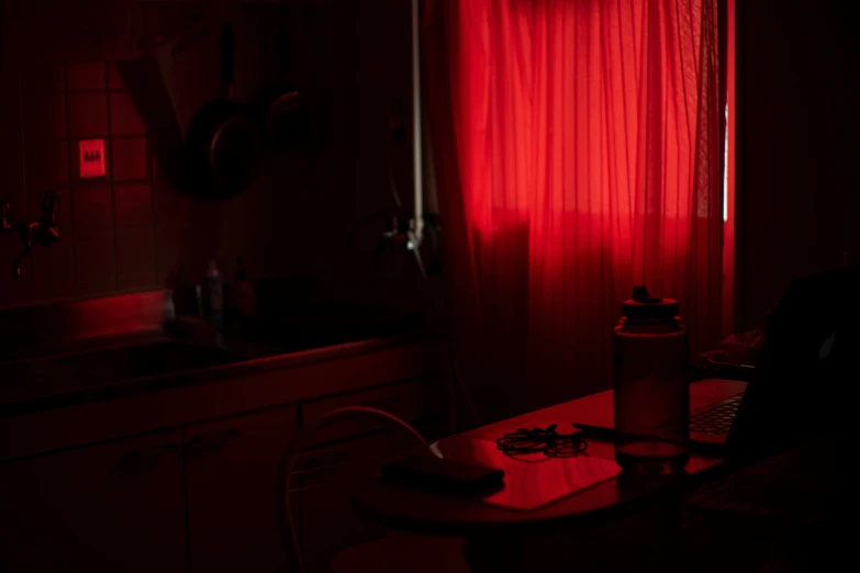 a kitchen that has a red light shining on the wall