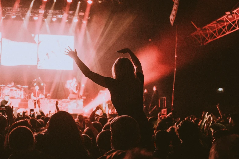 the crowd is in a dark auditorium while a woman in white is dancing