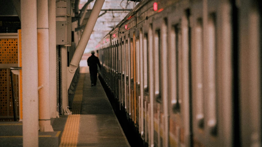 a man standing in the shadows at a train station