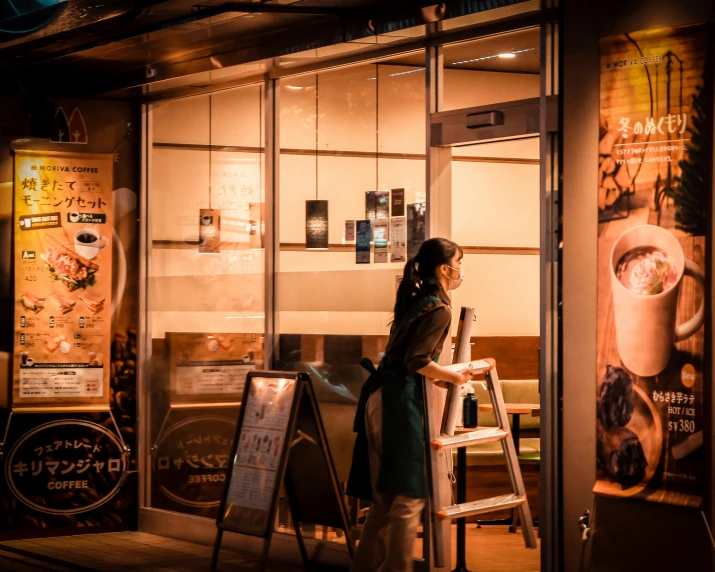 a woman looking out a glass door at coffee shop