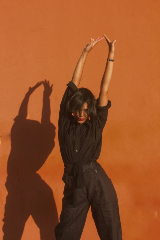 a woman wearing a black shirt jumping in the air