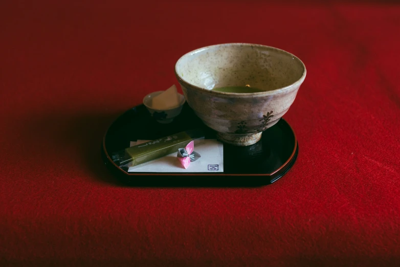 a small wooden cup and saucer are sitting on a plate