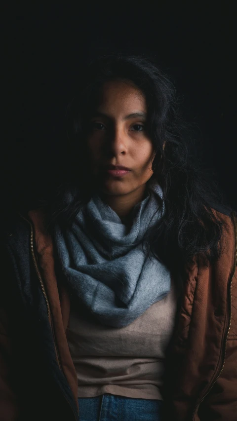 a woman with long dark hair and a scarf on