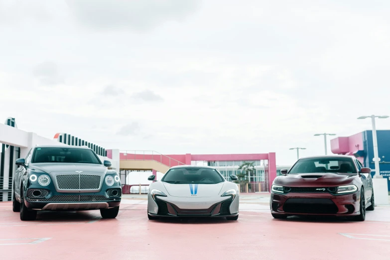 three cars sitting side by side in a parking lot