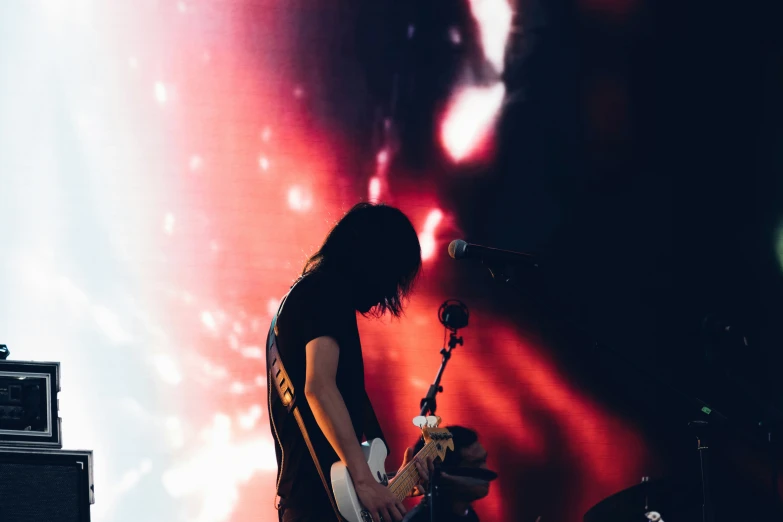 the young man is playing a guitar on stage