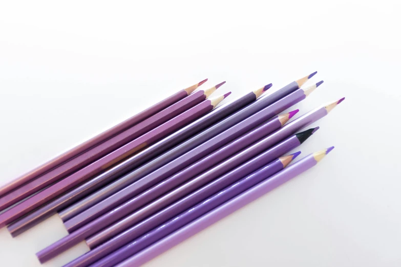 seven pencils laying side - by - side on a table