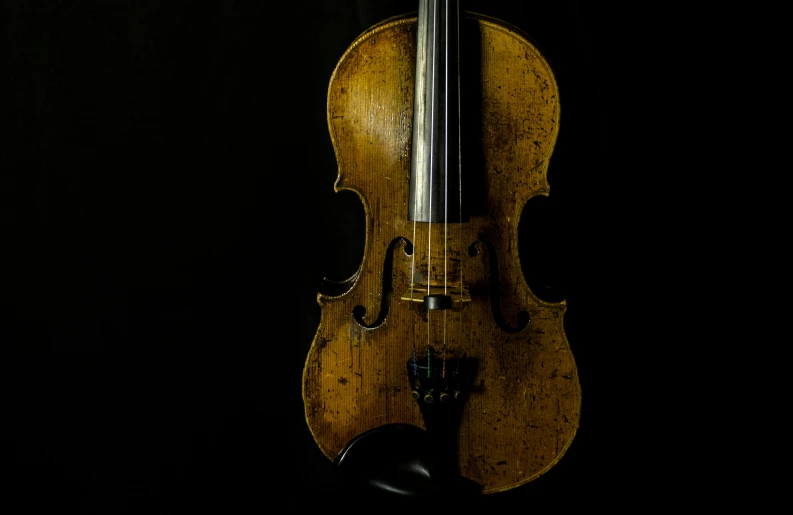 a violin is hanging up in the dark