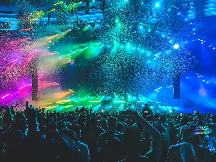 people watching a concert on stage with colorful lights