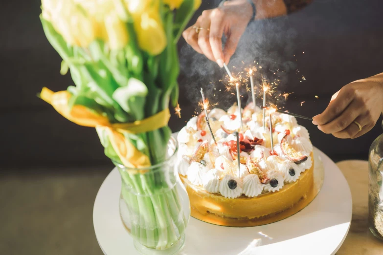 a person is adding sparklers on the cake