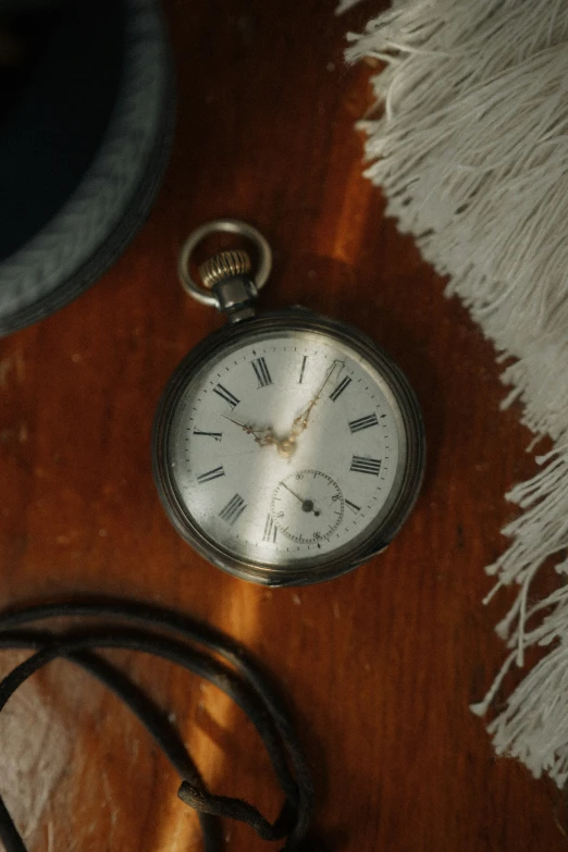 a clock lying on a rug with fringes
