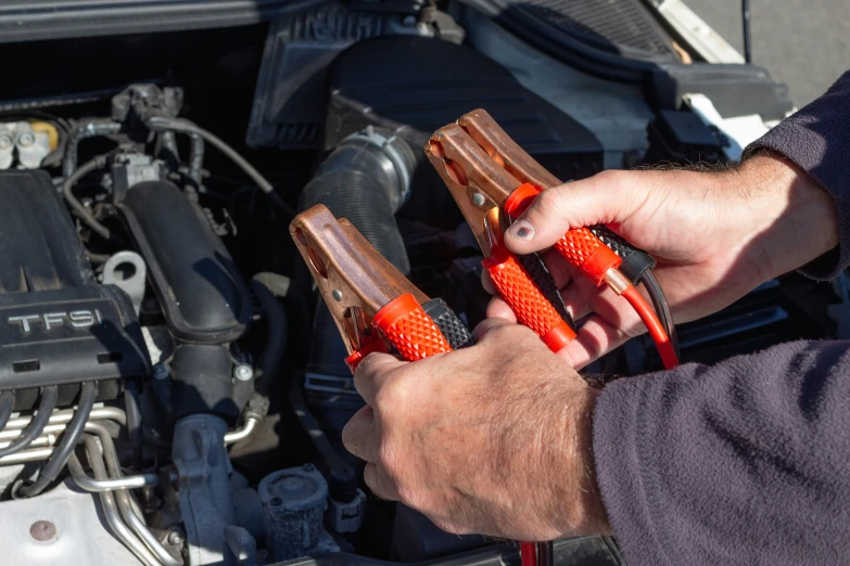 person working on the hood of an engine