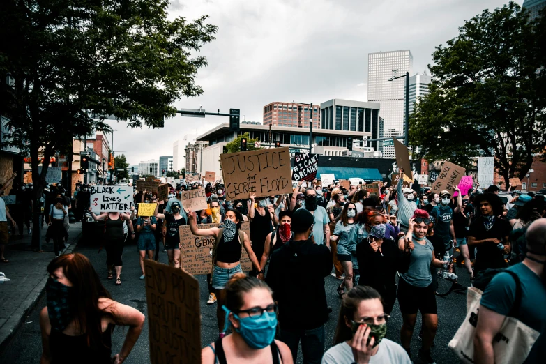 a group of people with masks and holding protest signs