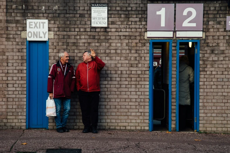 two men standing outside an exit only store front