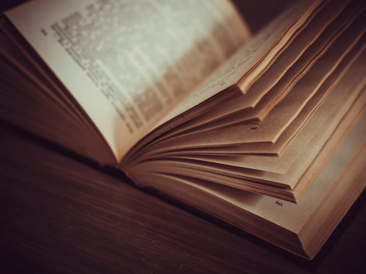 an open book on the table has pages stacked together