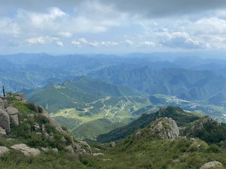 there are mountains in the distance with a person standing on a hill